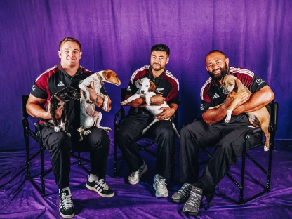 All Blacks interviewed with a lap full of puppies